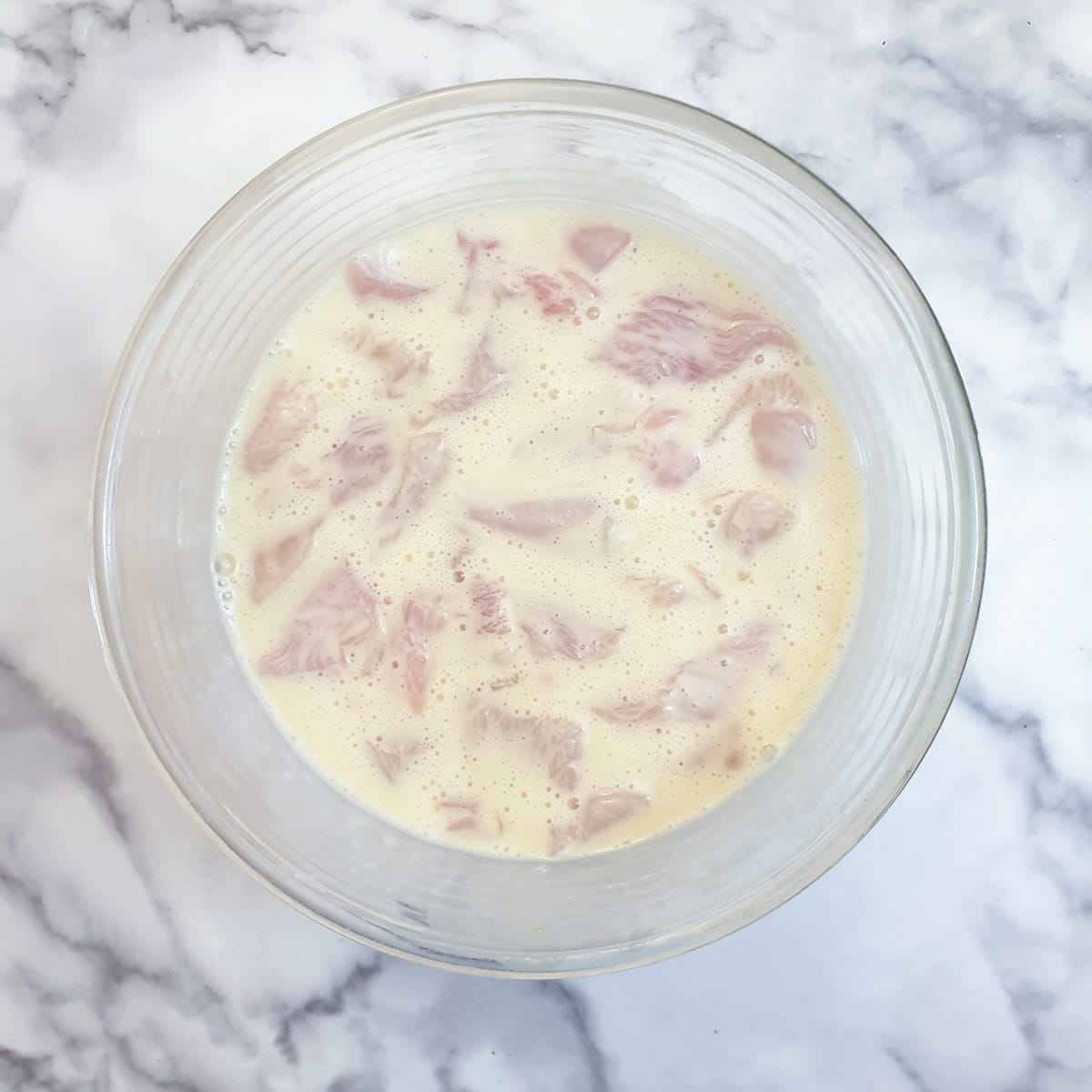 Chicken pieces in a mixture of eggs and cornflour.