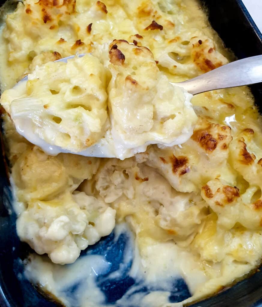 Close up of cauliflower florets in a cheese sauce.