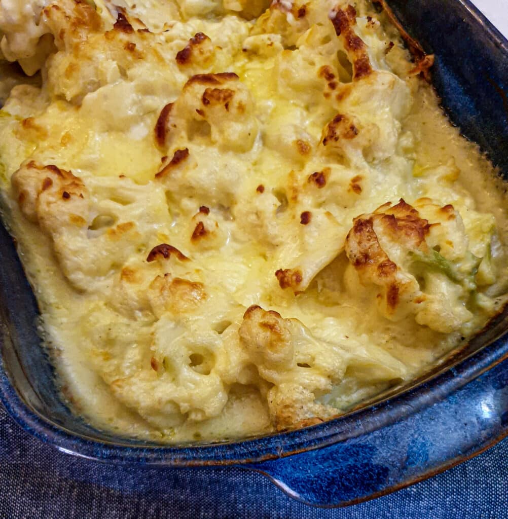 Closeup of the top of a dish of browned cauliflower cheese.