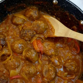 Close up of meatballs in a curried onion gravy.