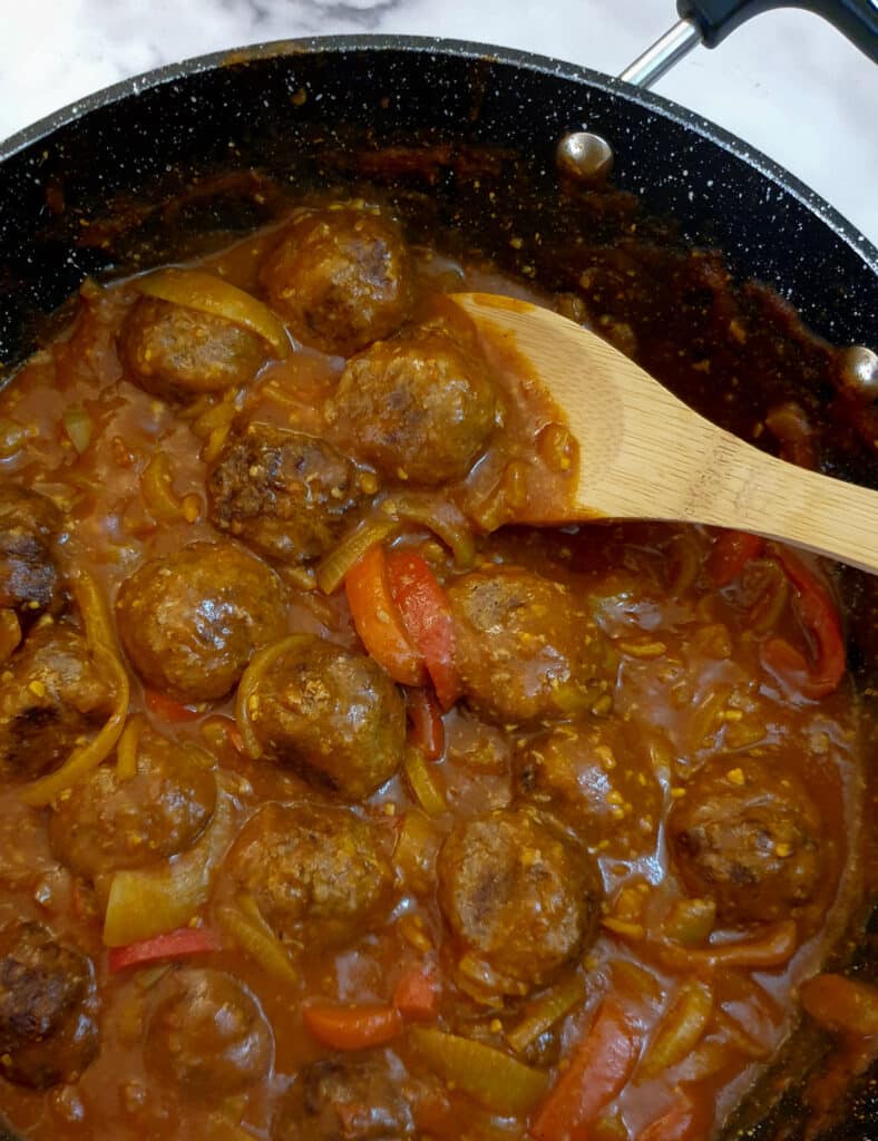 Close up of meatballs in a curried onion gravy.