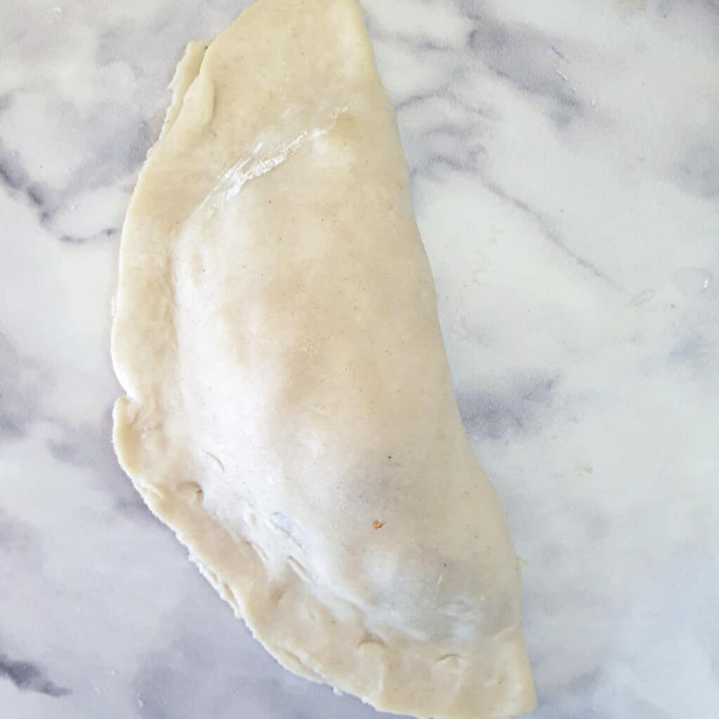 A cornish pasty folded in half before being crimped.