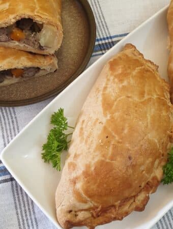 A cornish pasty on a white plate.