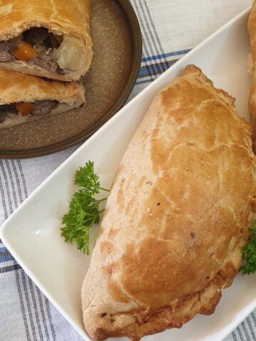 A cornish pasty on a white plate.