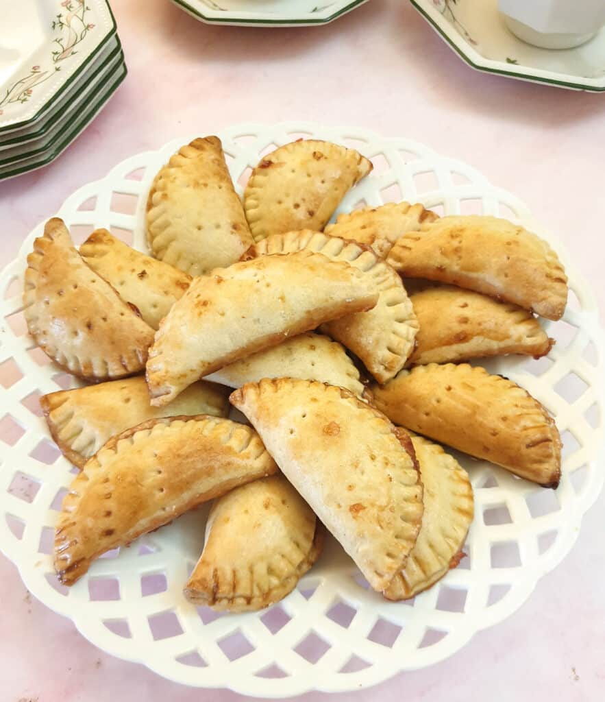 A pile of jam turnovers on a white plate.