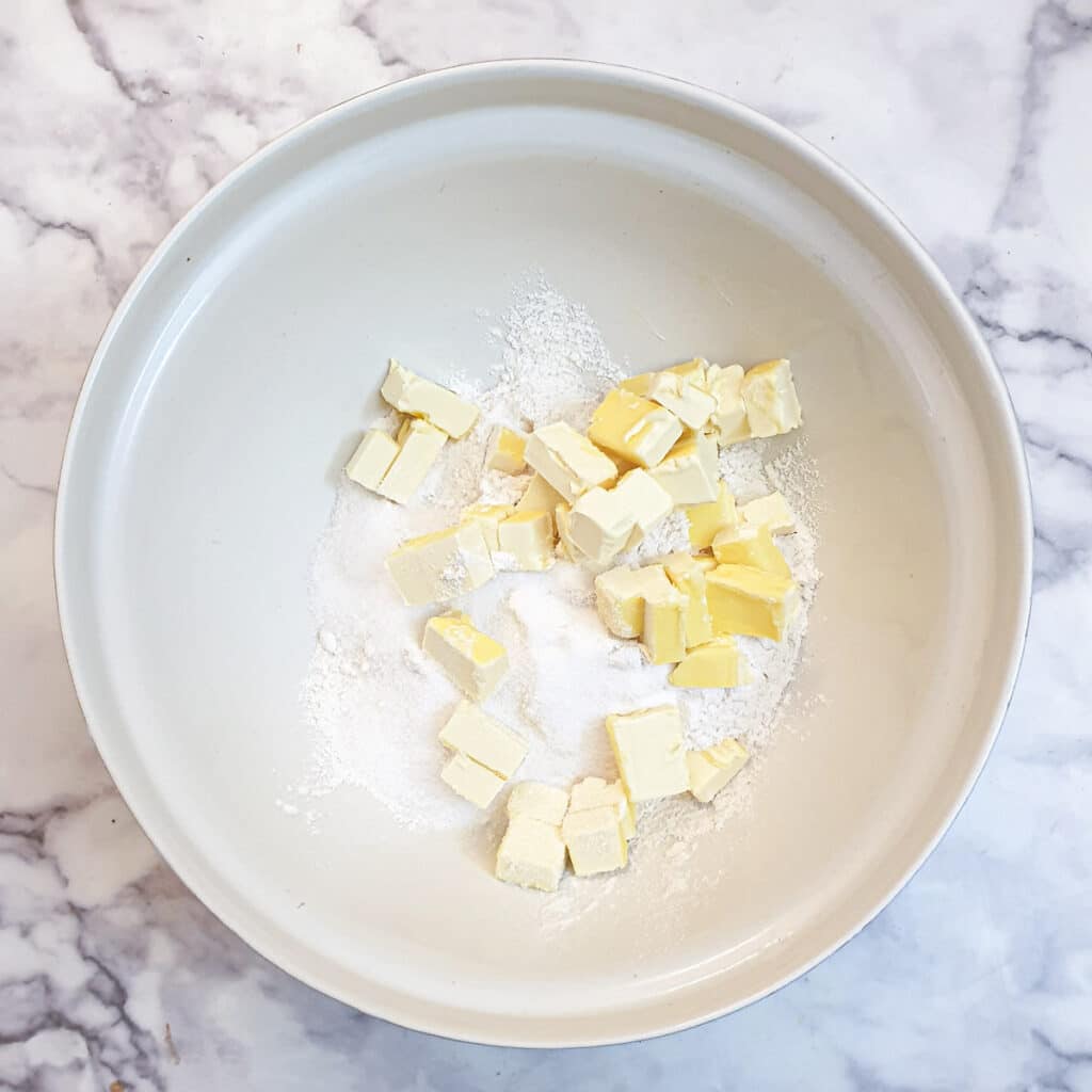 Cubed butter in a bowl of flour.