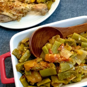 A dish of Middle Eastern-style runner beans with a wooden serving spoon.