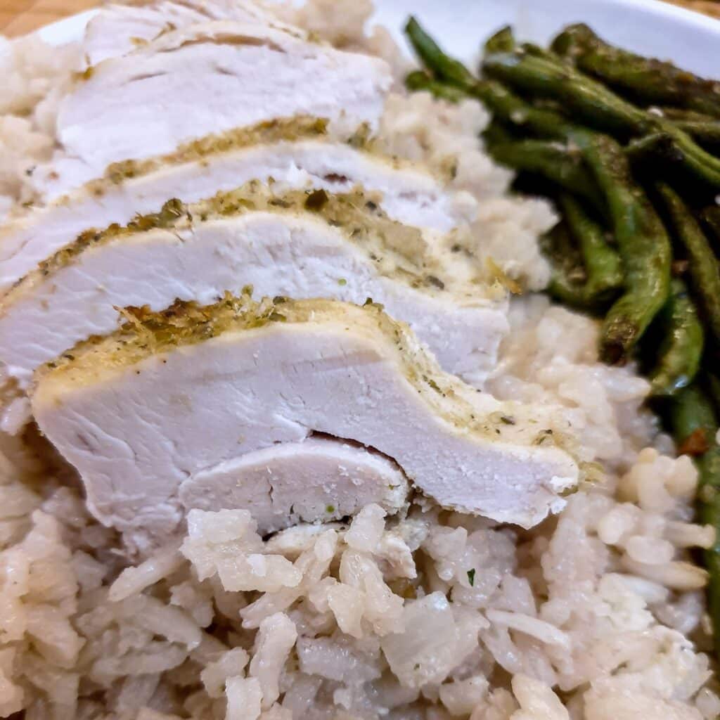 Slices of Thai-flavoured chicken breast on a bed of rice.