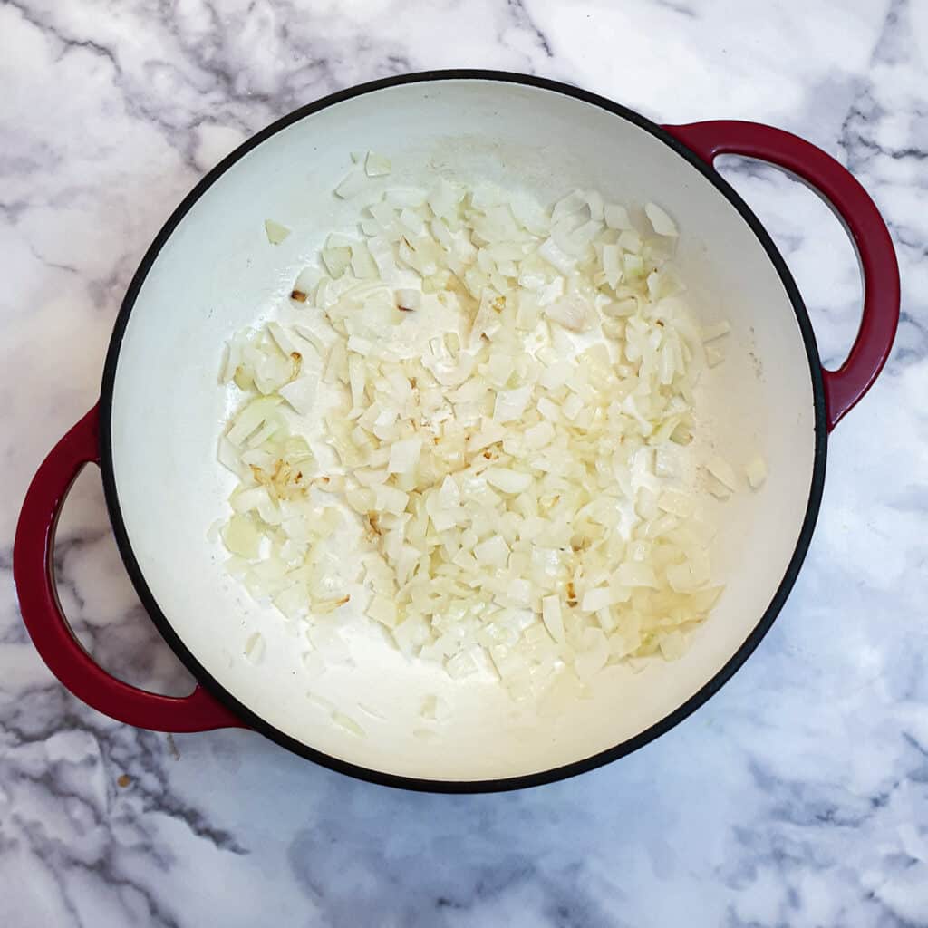 Onions softening in a large pan.