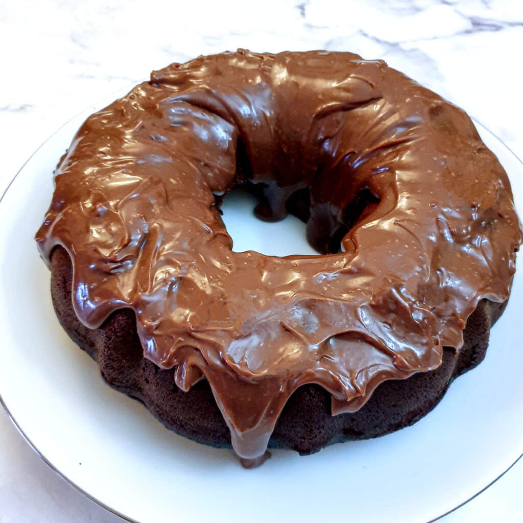 A round condensed milk chocolate bundt cake covered in chocolate ganache.