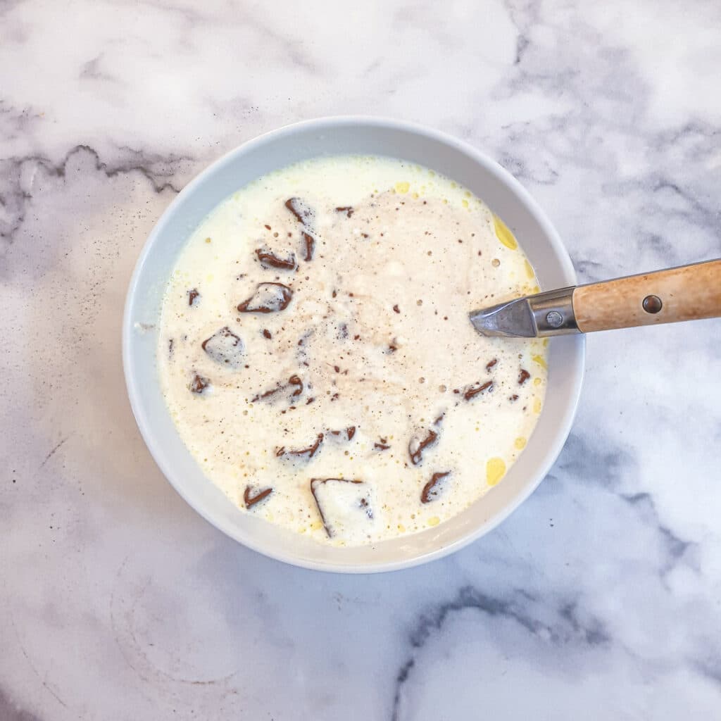 Cream and pieces of chocolate in a small bowl.