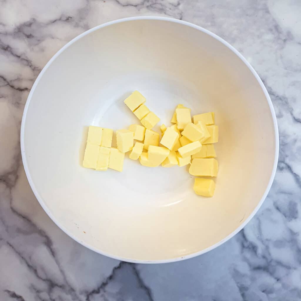 Cubes of butter in a white mixing bowl.