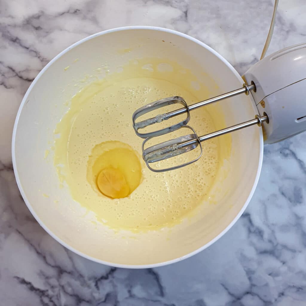 An egg in a bowl of butter and condensed milk.