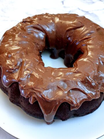 A round condensed milk chocolate bundt cake covered in chocolate ganache.