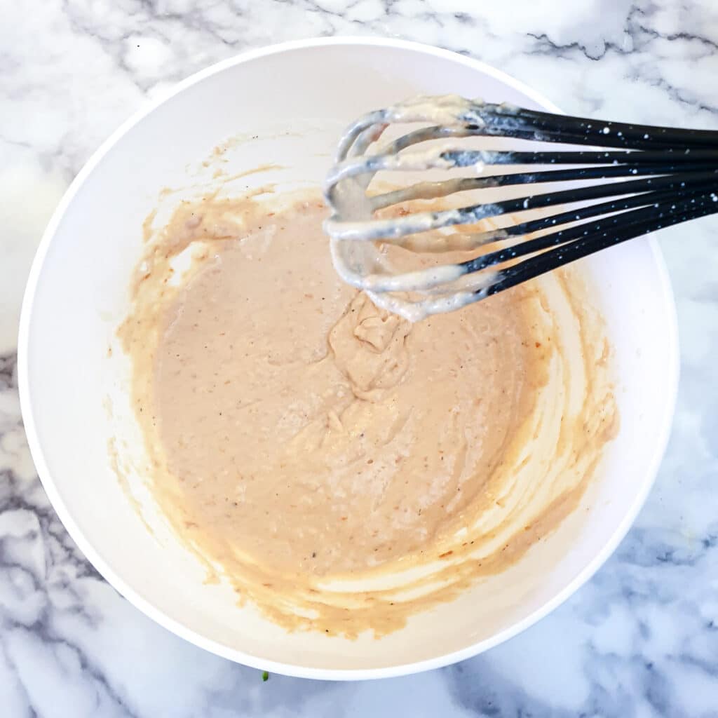 Eggs, flour and passata mixed to a batter in a mixing bowl.