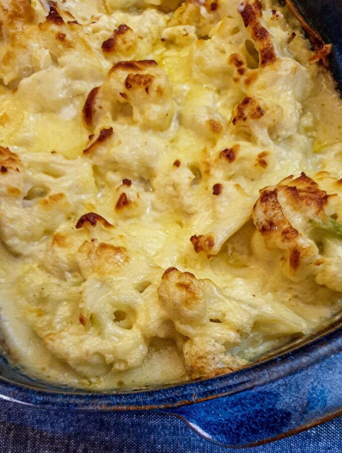 Closeup of the top of a dish of browned cauliflower cheese.