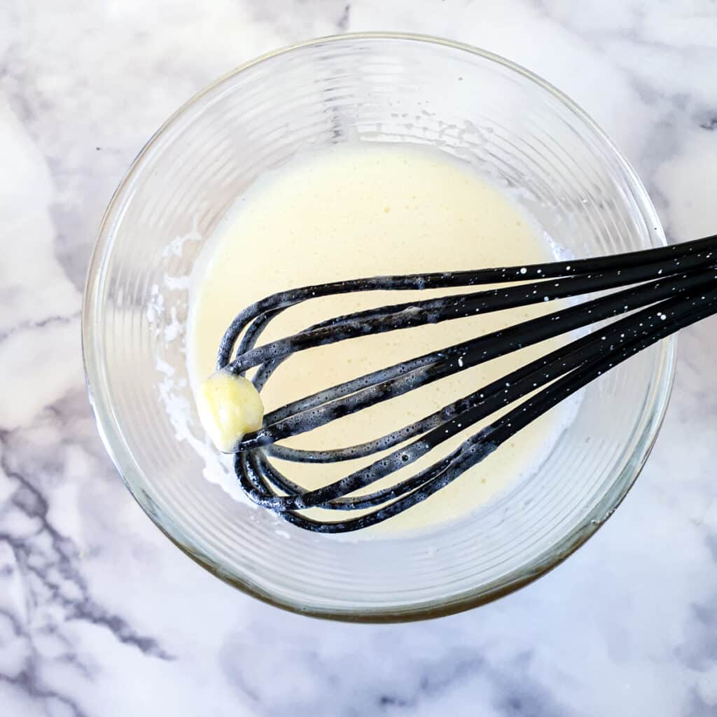 A balloon whisk with a piece of semi-melted butter on the end.