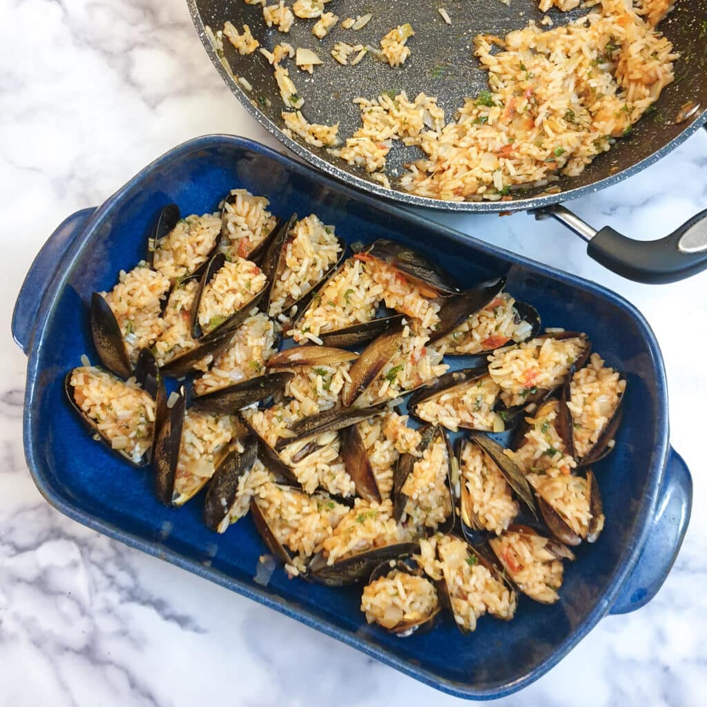 A blue baking dish filled with stuffed mussels.