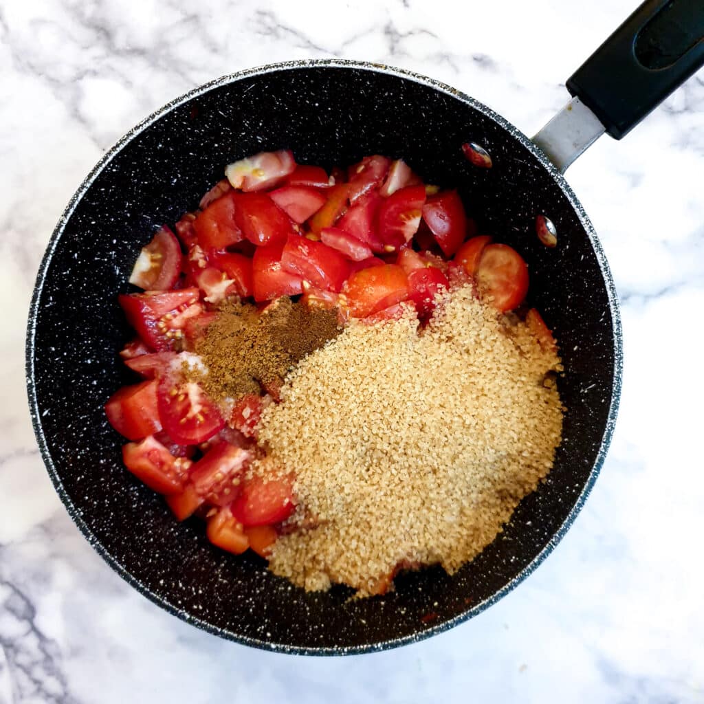 Chopped tomatoes, brown sugar, vinegar and spices in a saucepan.