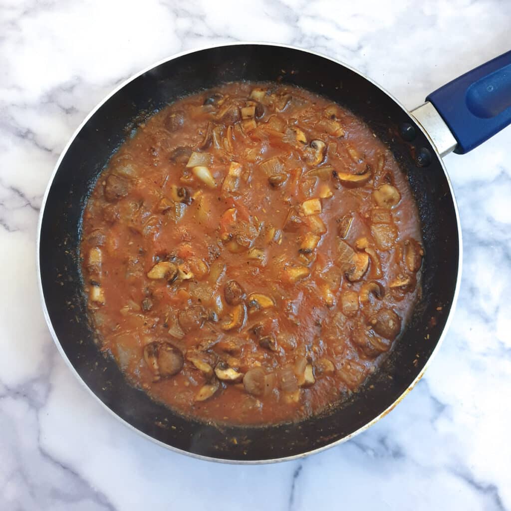 A frying pan of cooked tomato sauce.