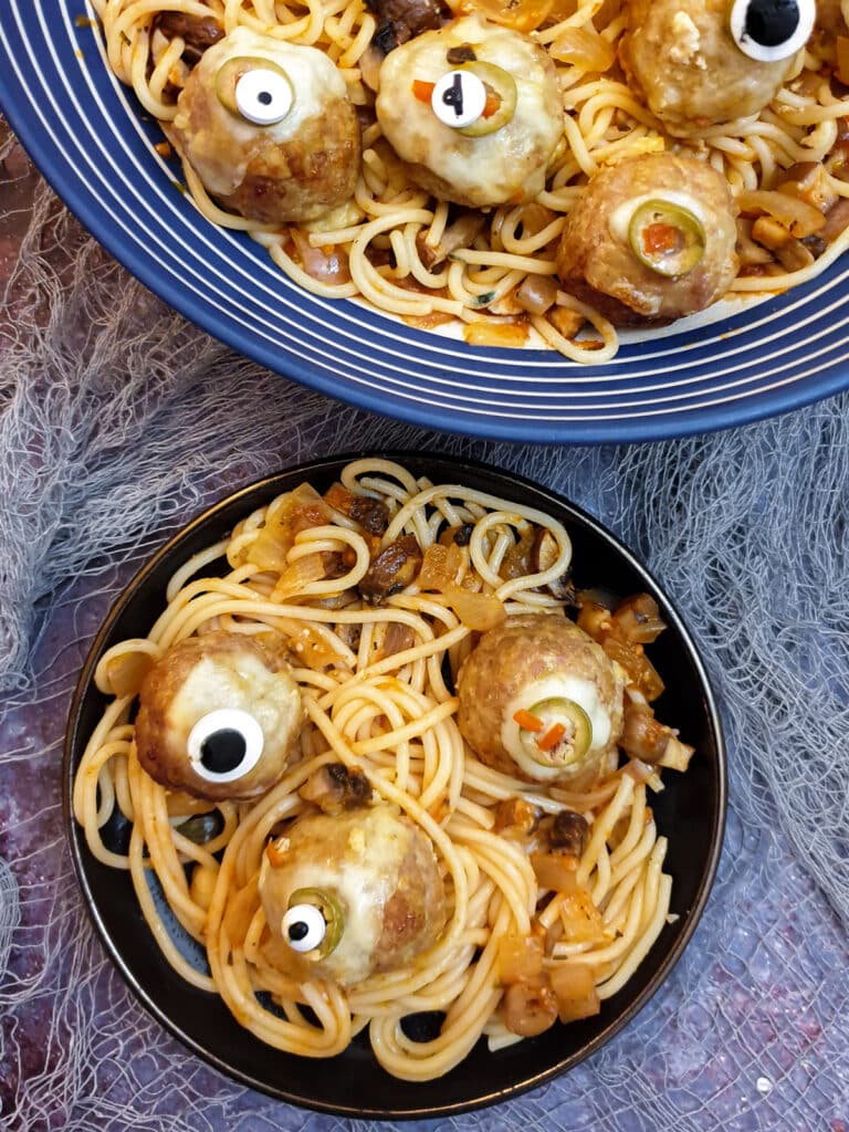 A black plate with three Halloween 'eyes' on a bed of spaghetti worms.