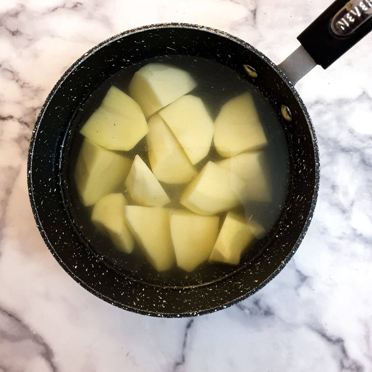 Potatoes in a saucepan of water.