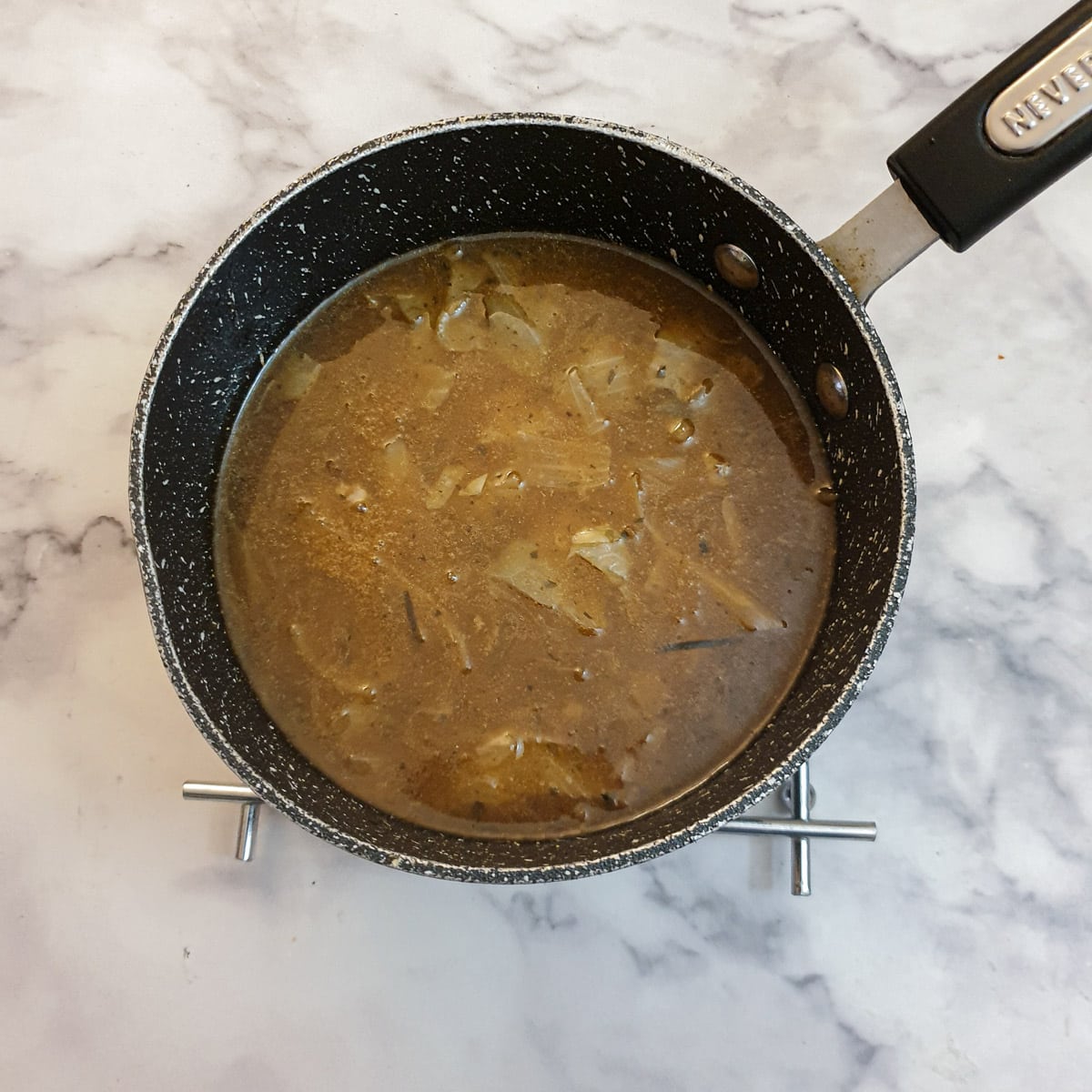 A saucepan of gravy thickened with cornflour.