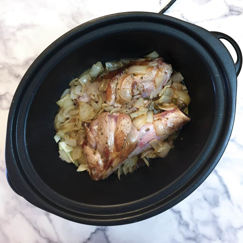 Fried onions added to lamb shanks in a slow cooker.