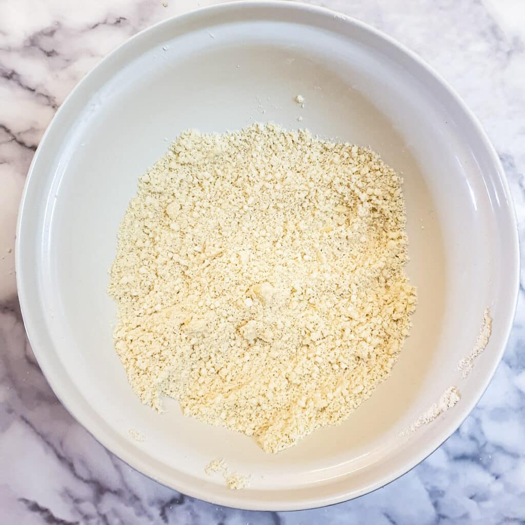 Butter and suet rubbed into flour to form coarse breadcrumbs in a mixing bowl.
