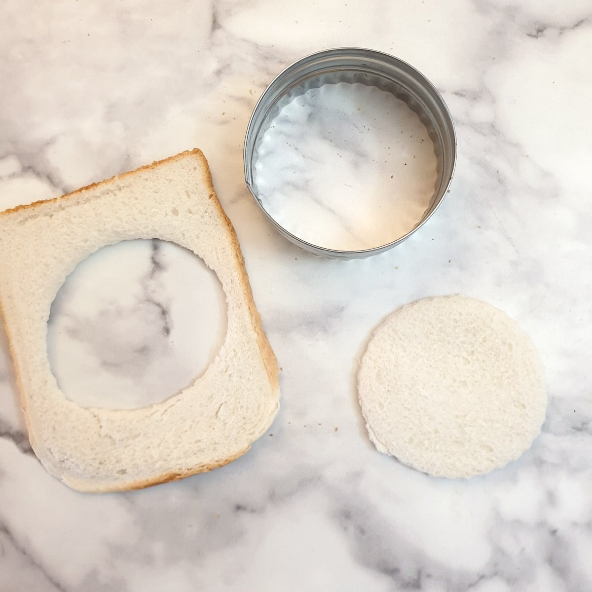A circle of bread cut from a slice of bread with a scone cutter.