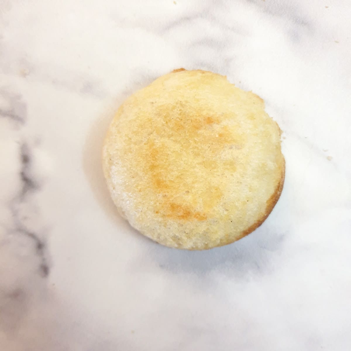 The underneath side of a baked breadcup showing the degree of brownness.