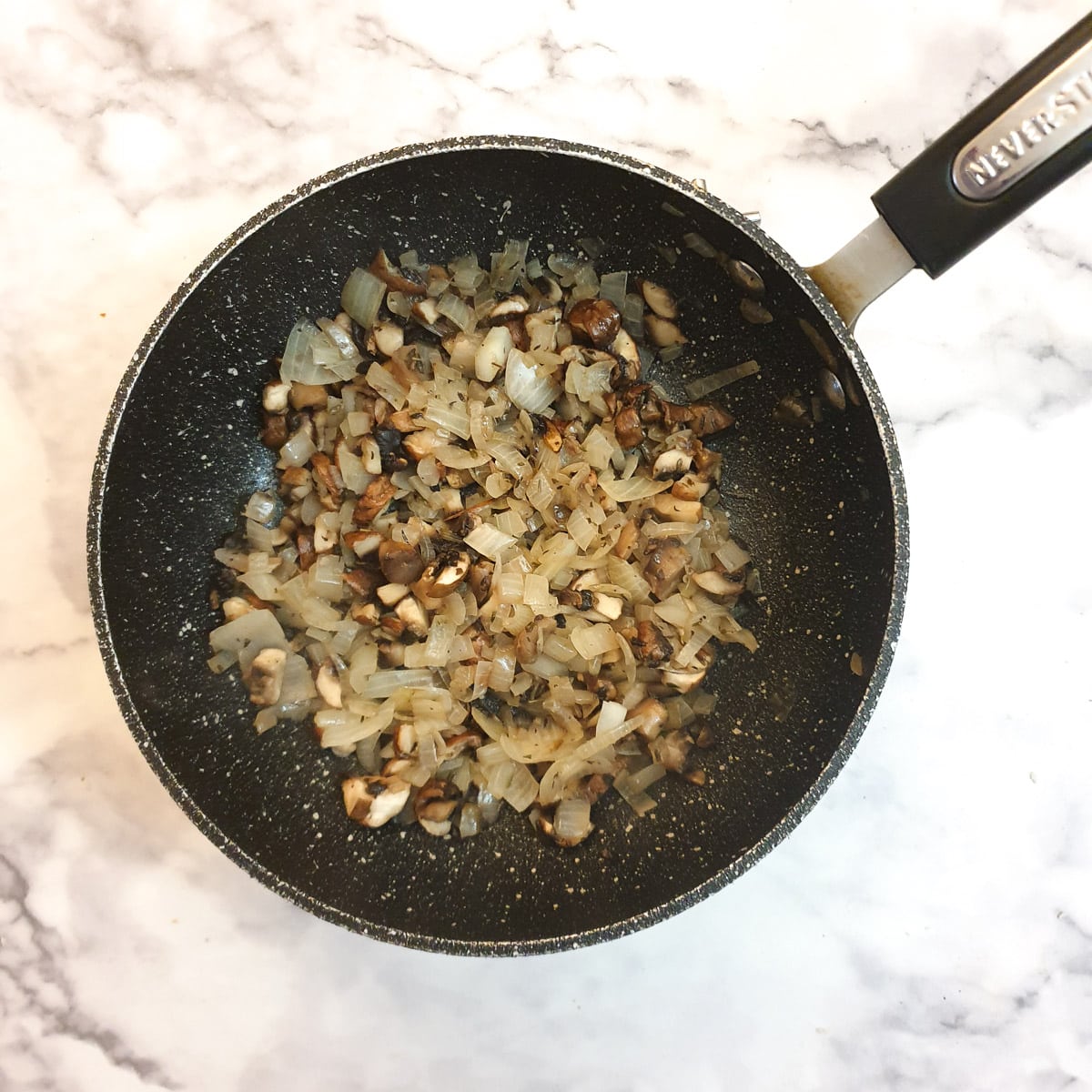 Fried mushrooms and onions in a frying pan.