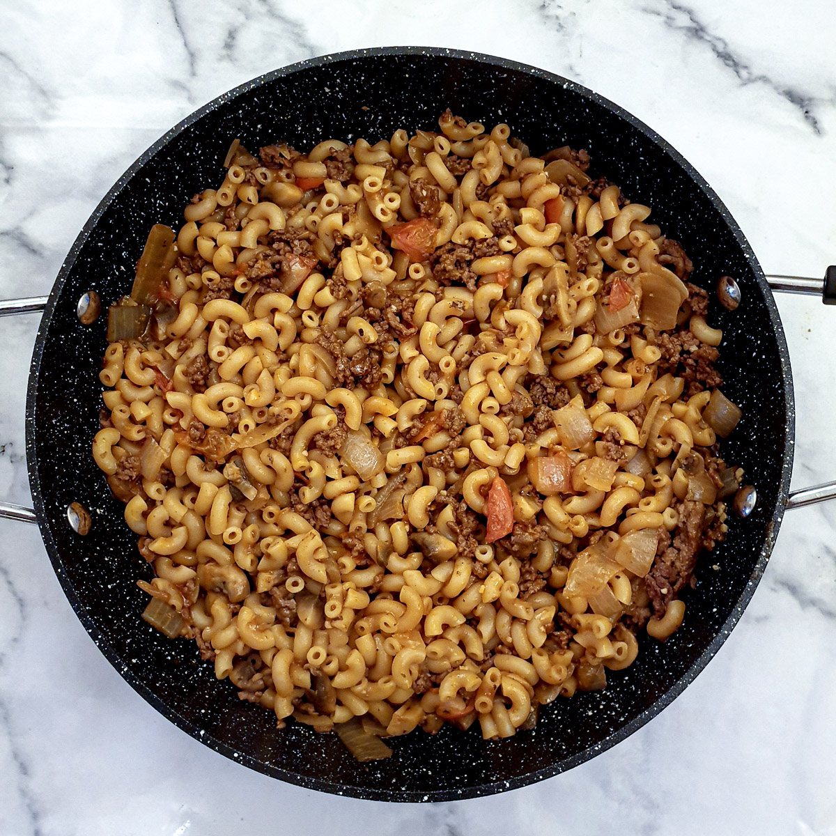 Cooked pasta in the pan of goulash.