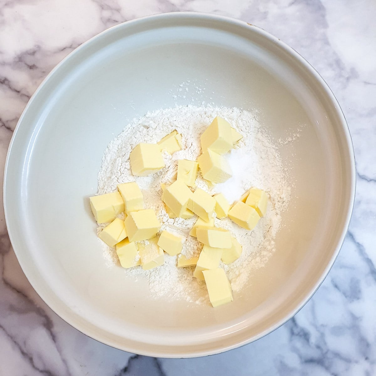 Flour and cubed butter in a mixing bowl.