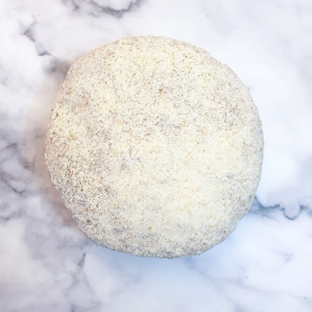 A round disk of dough covered with grated parmesan cheese.