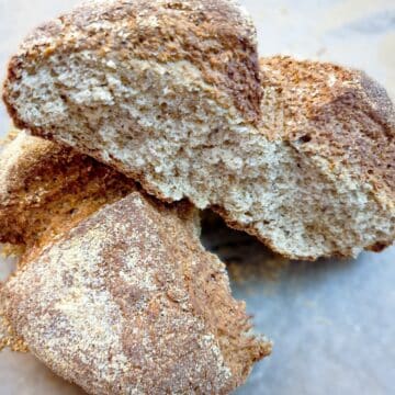 A baked loaf of cheese wholemeal soda bread cut in half to show the inside.