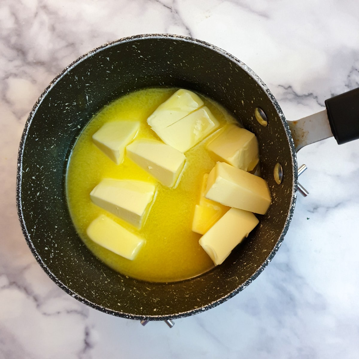 Cubes of butter melting in a saucepan.