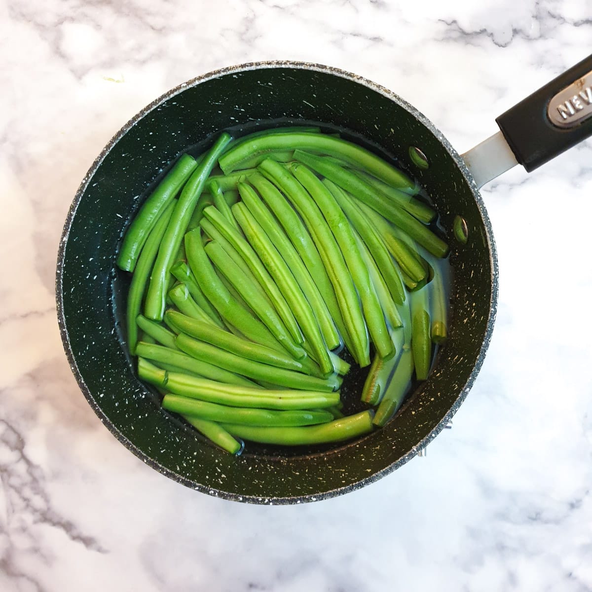 Green beans in a saucepan of water.