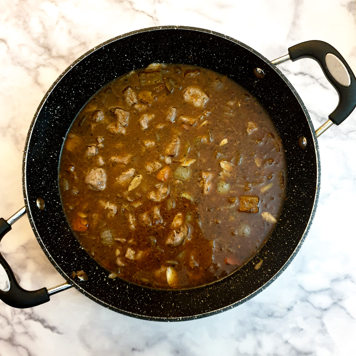 Moroccan lamb pie filling in a frying pan before being cooked.