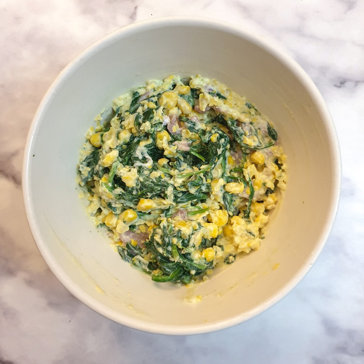 Mixed butternut stuffing ingredients in a white mixing bowl.