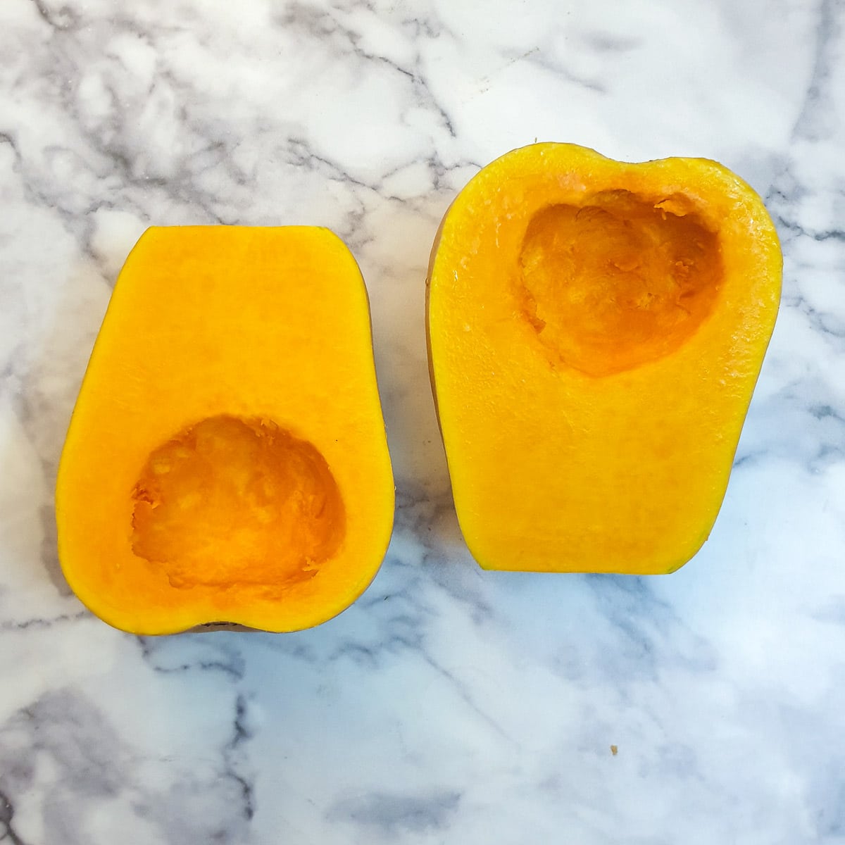 Two halves of butternut side by side with the seeds removed.