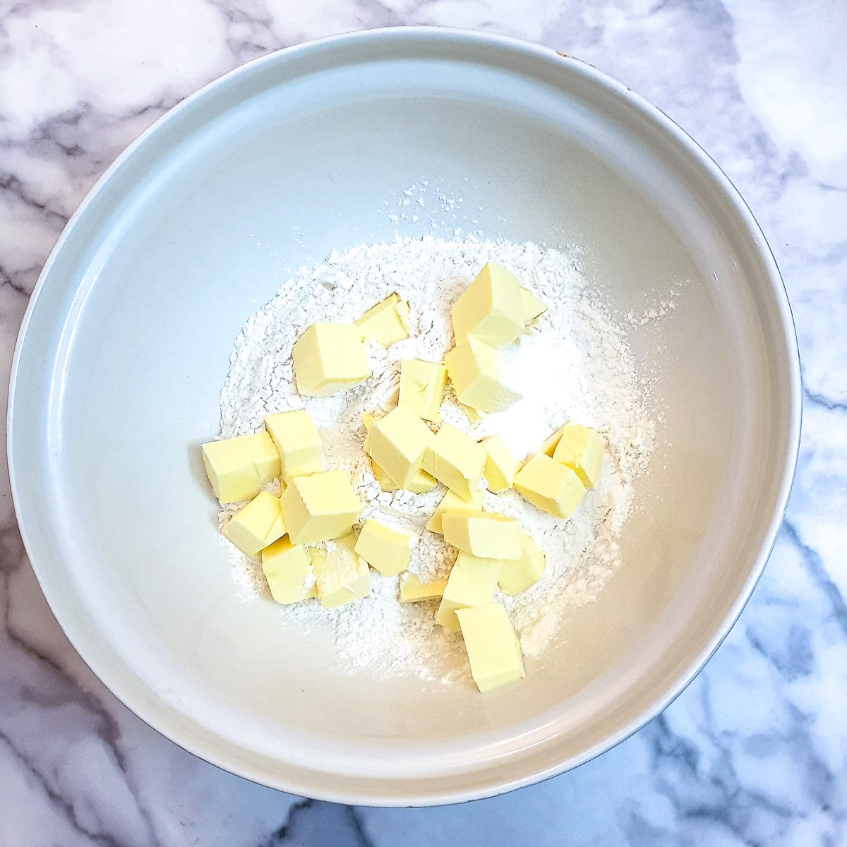 Cubed butter and flour in a large mixing bowl.