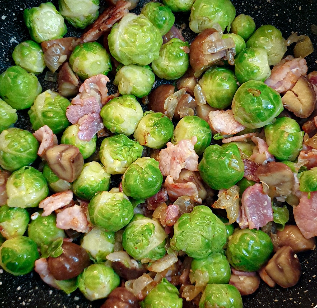 Close up of brussels sprouts with chestnuts and bacon.