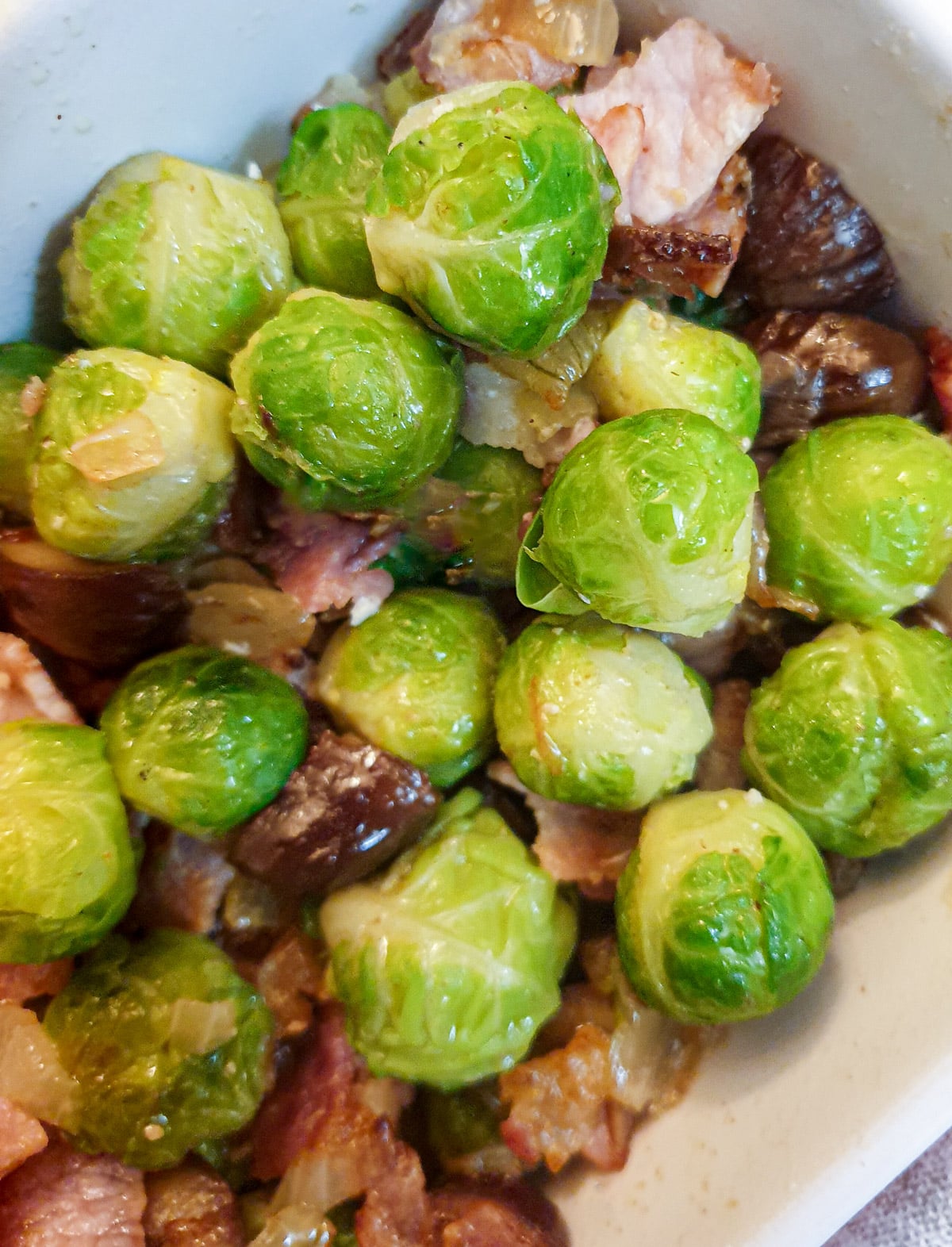 Close up of brussels sprouts with chestnuts, bacon and onions.