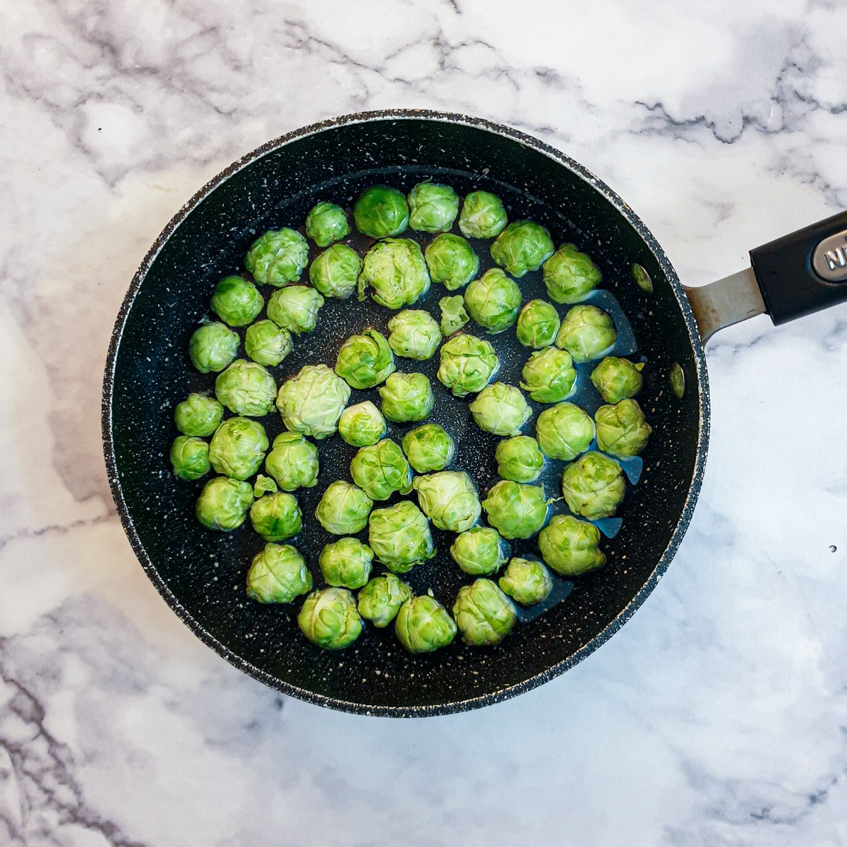 Brussels sprouts in a saucepan of water.
