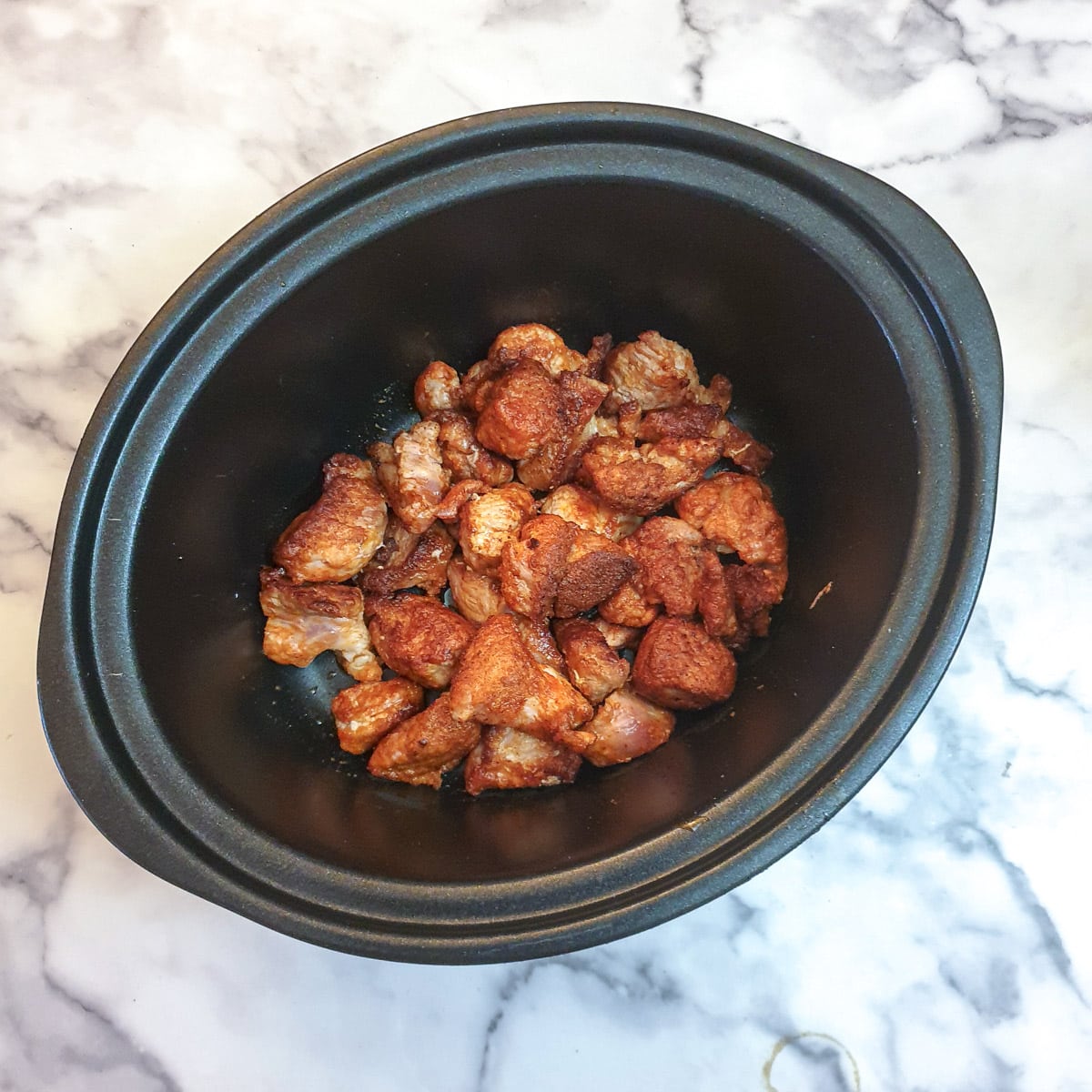 Browned pork in a slow-cooker.