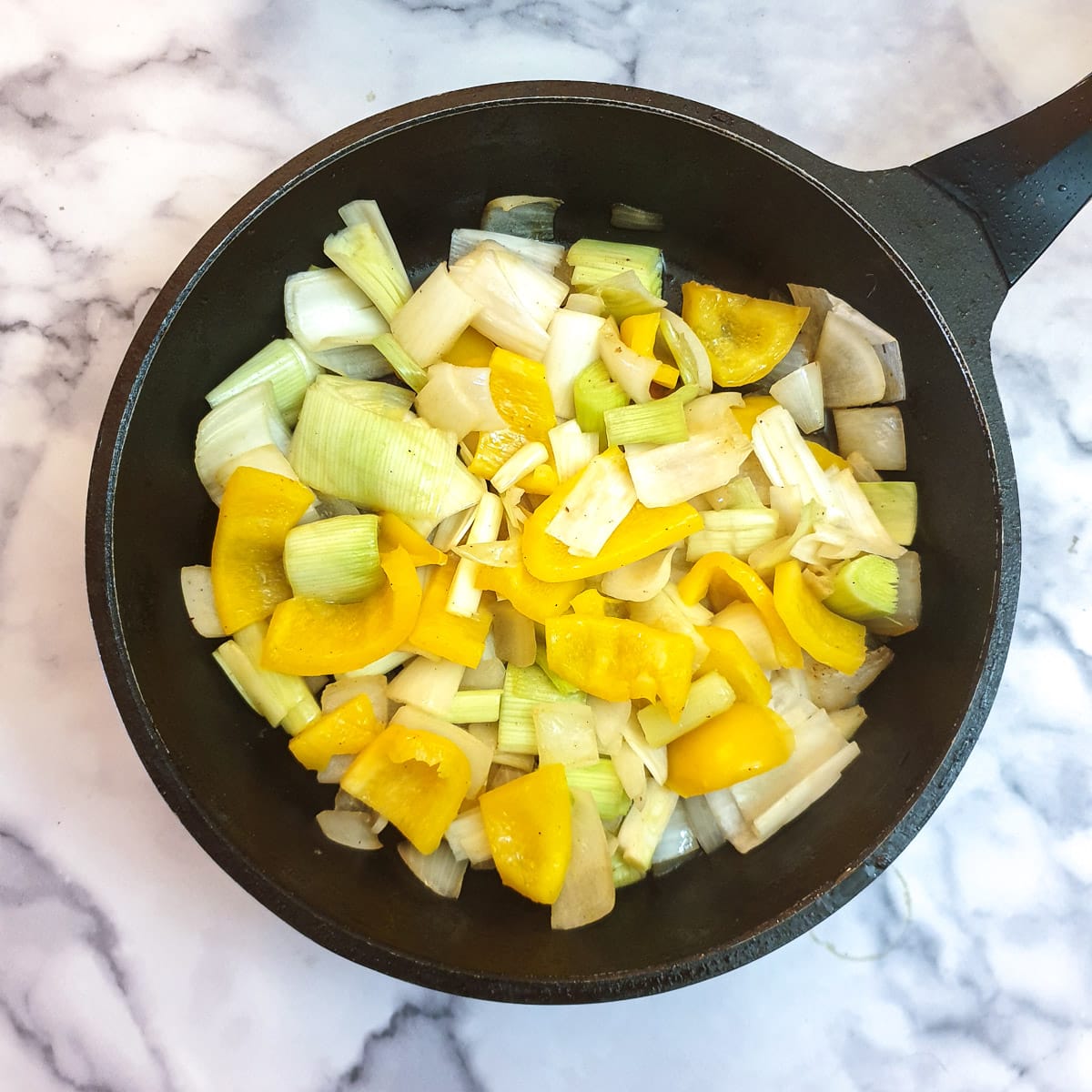 Chopped onions, leeks and yellow pepper in a frying pan,