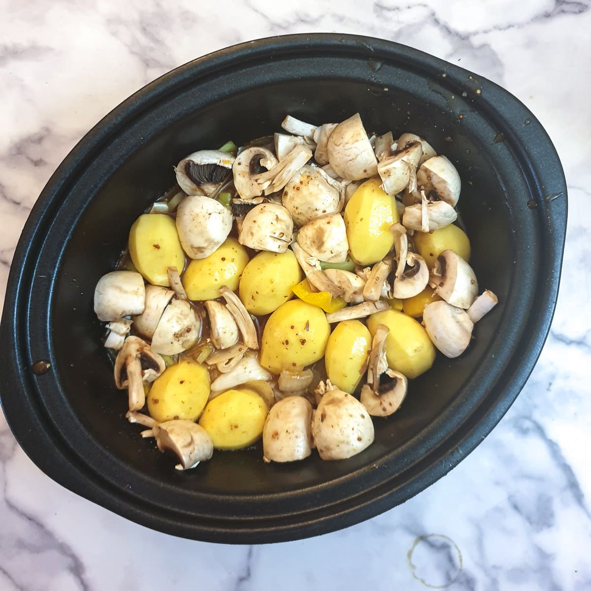 Potatoes, mushrooms and stock added to the pork casserole.