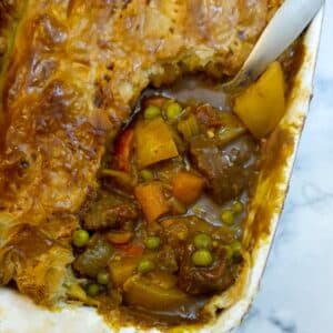 Overhead shot of beef curry pie with a corner cut away to show the filling.