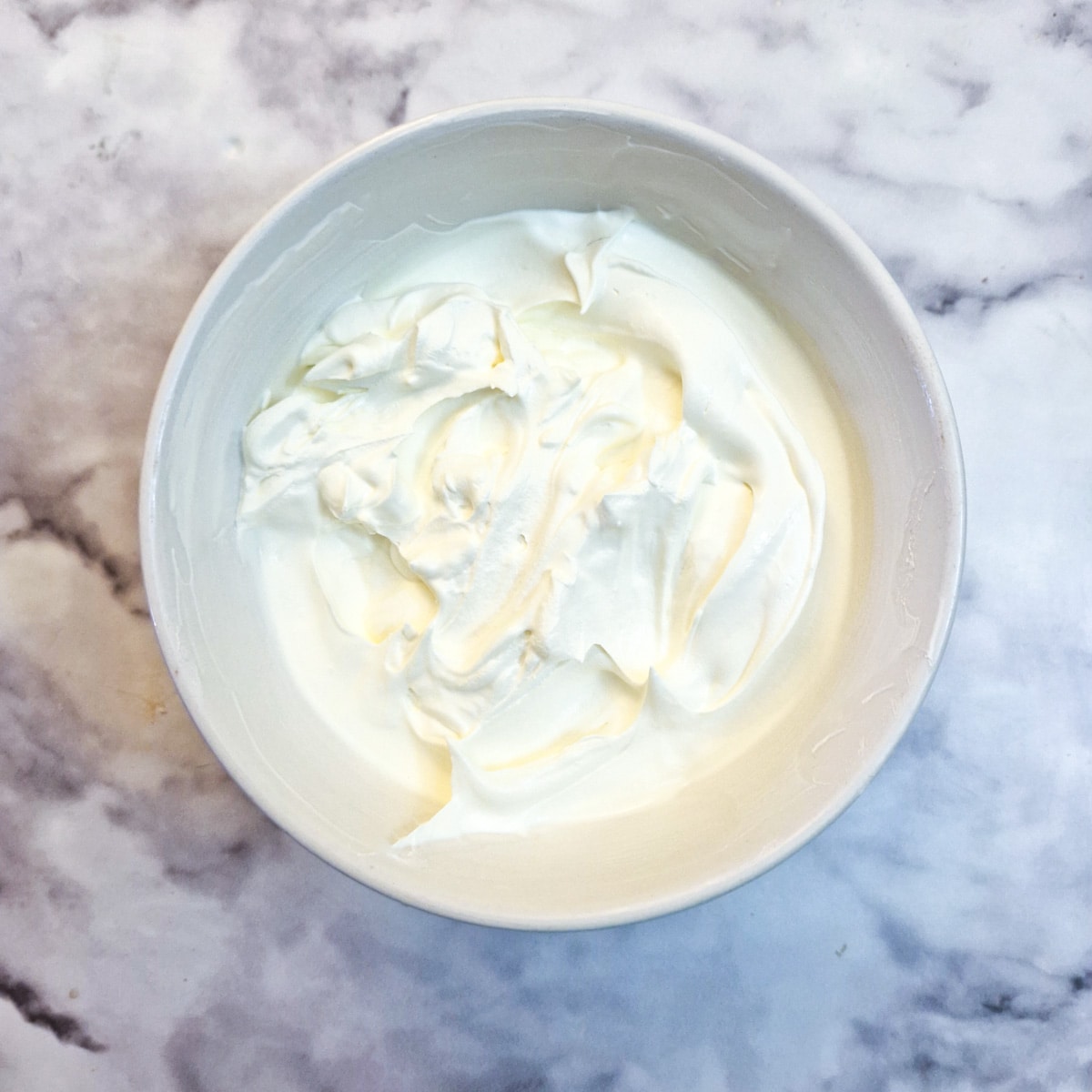 Whipped cream in a small white bowl.